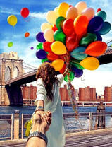Охапка воздушных шаров у девушки под мостом